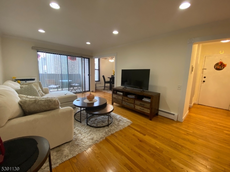 824 Main Street, Unit J Belleville, NJ 07109 - Photo 14 of 24 a living room with furniture and a flat screen tv