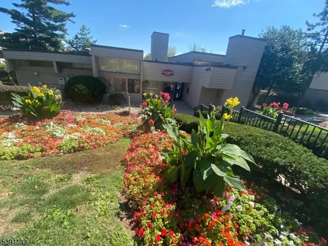 a front view of a house with a yard and a garden