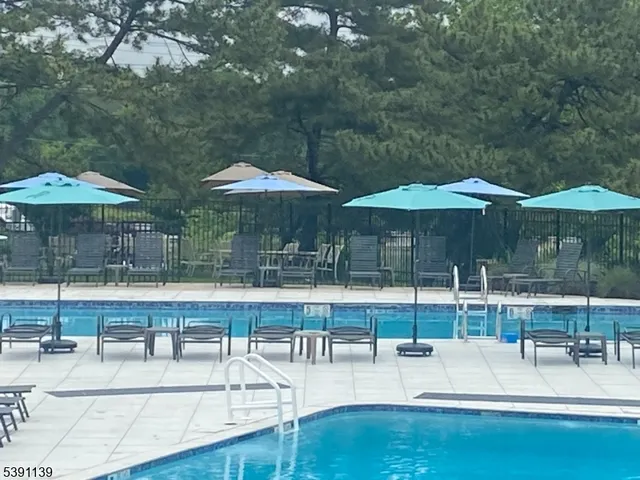 a view of a swimming pool with chairs in patio