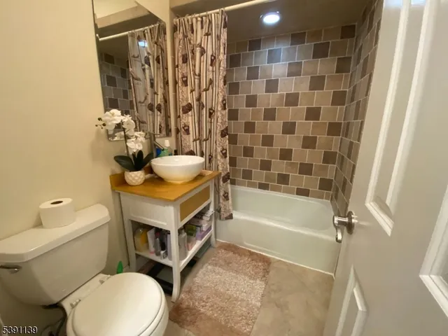 a white toilet sitting next to a bath tub