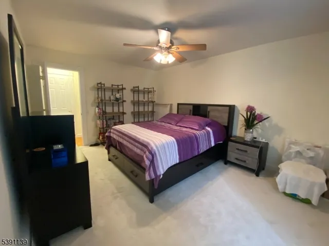 a spacious bedroom with a bed and a chandelier