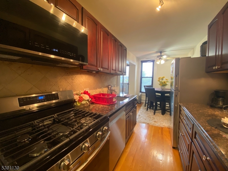 824 Main Street, Unit J Belleville, NJ 07109 - Photo 9 of 24 a kitchen with stainless steel appliances kitchen island granite countertop a stove a sink and dishwasher