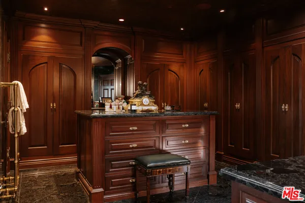 a bedroom with a large bed a chandelier and dresser