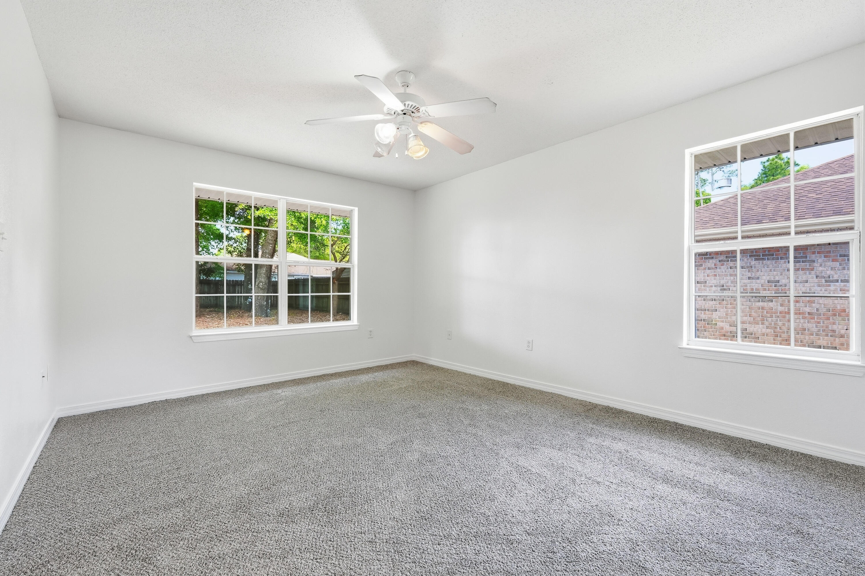 4087 Audiss Road Milton, FL 32583 - Photo 21 of 34 an empty room with windows and chandelier fan