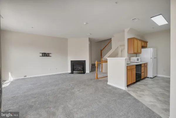 a view of a kitchen with a sink a microwave and cabinets