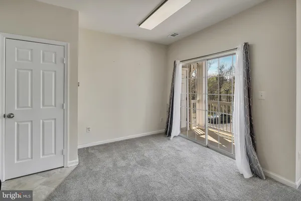 an empty room with a fireplace and windows