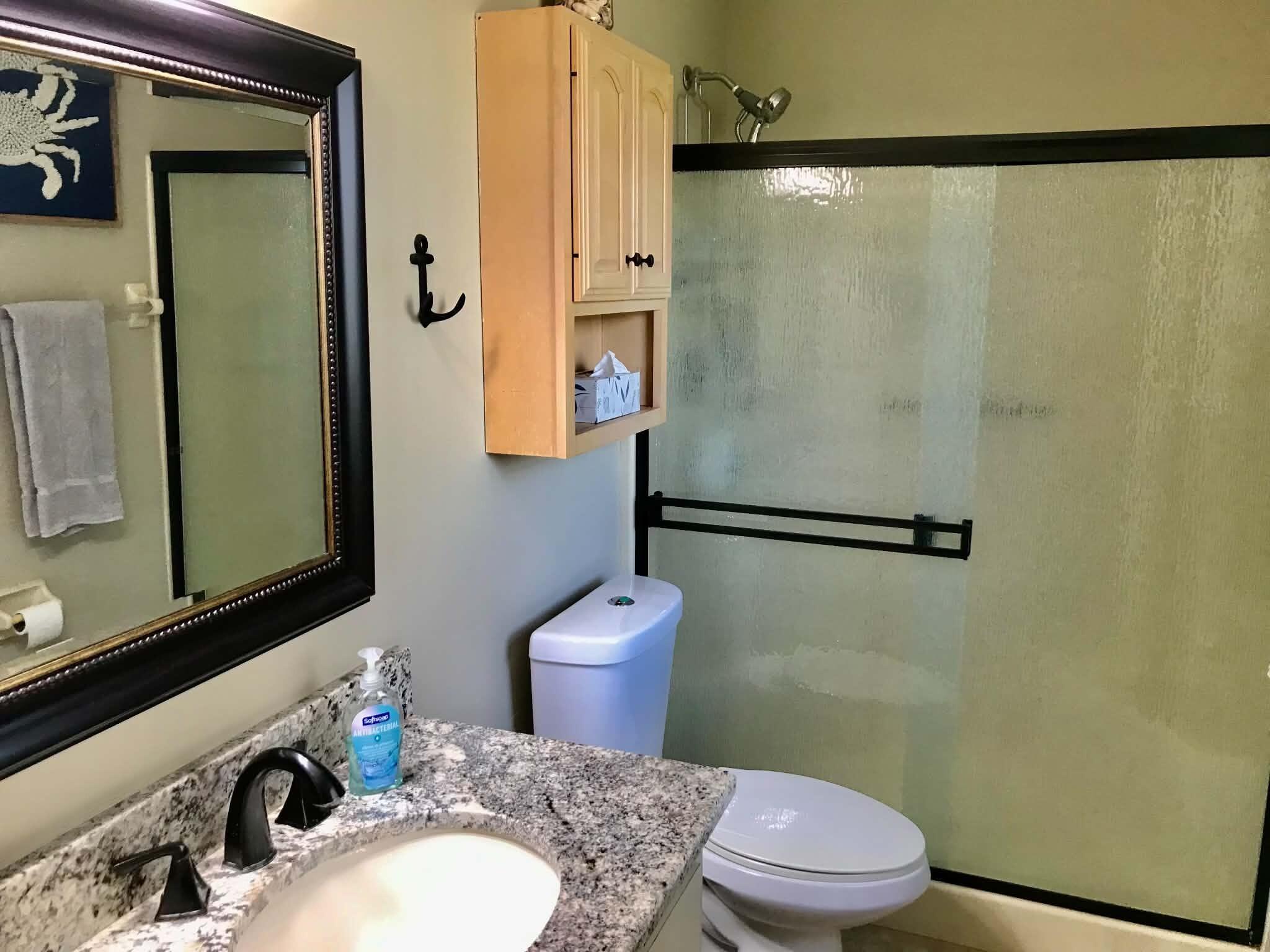 1115 Elm Street Okeechobee, FL 34974 - Photo 20 of 37 a bathroom with a granite countertop toilet sink shower and mirror