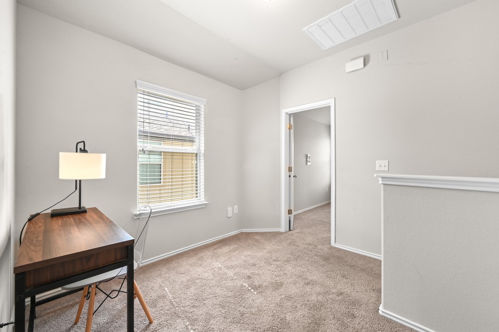 209 Noddy Road Buda, TX 78610 - Photo 16 of 27 Soft carpeting and a bright window define this versatile upper-level flex space.