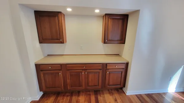 a view of a kitchen with wooden floor and cabinets