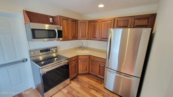 a kitchen with granite countertop a refrigerator and a sink