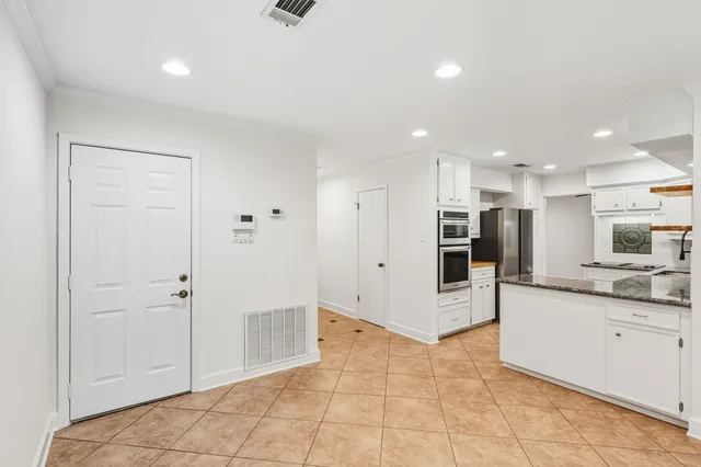 a large kitchen with stainless steel appliances kitchen island granite countertop a refrigerator oven a sink and dishwasher