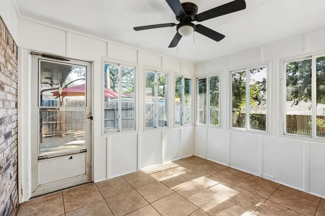 an empty room with a window and a fan