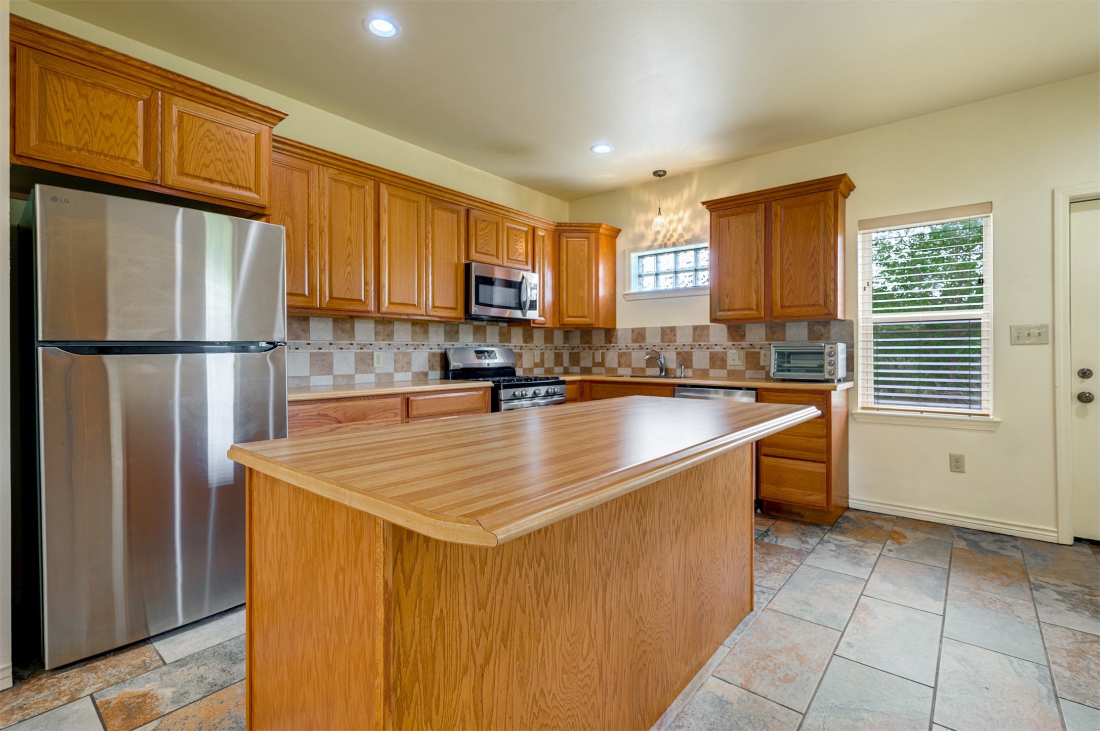 531 County Road 3501 Cuney, TX 75759 - Photo 14 of 45 a kitchen with stainless steel appliances granite countertop a refrigerator a sink a stove a washer dryer and a window