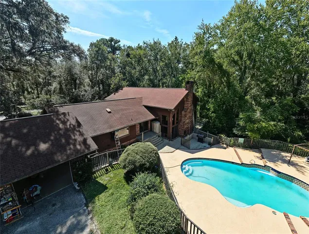 an aerial view of a house with swimming pool patio and outdoor seating