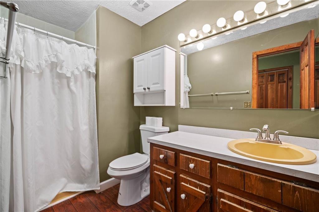 1996 Thomas Road Canton, GA 30115 - Photo 17 of 48 a bathroom with a sink a toilet and a mirror