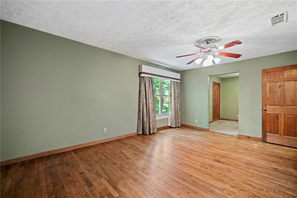 1996 Thomas Road Canton, GA 30115 - Photo 18 of 48 an empty room with wooden floor and chandelier fan