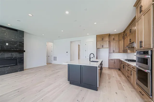 a large kitchen with stainless steel appliances granite countertop a stove and a refrigerator