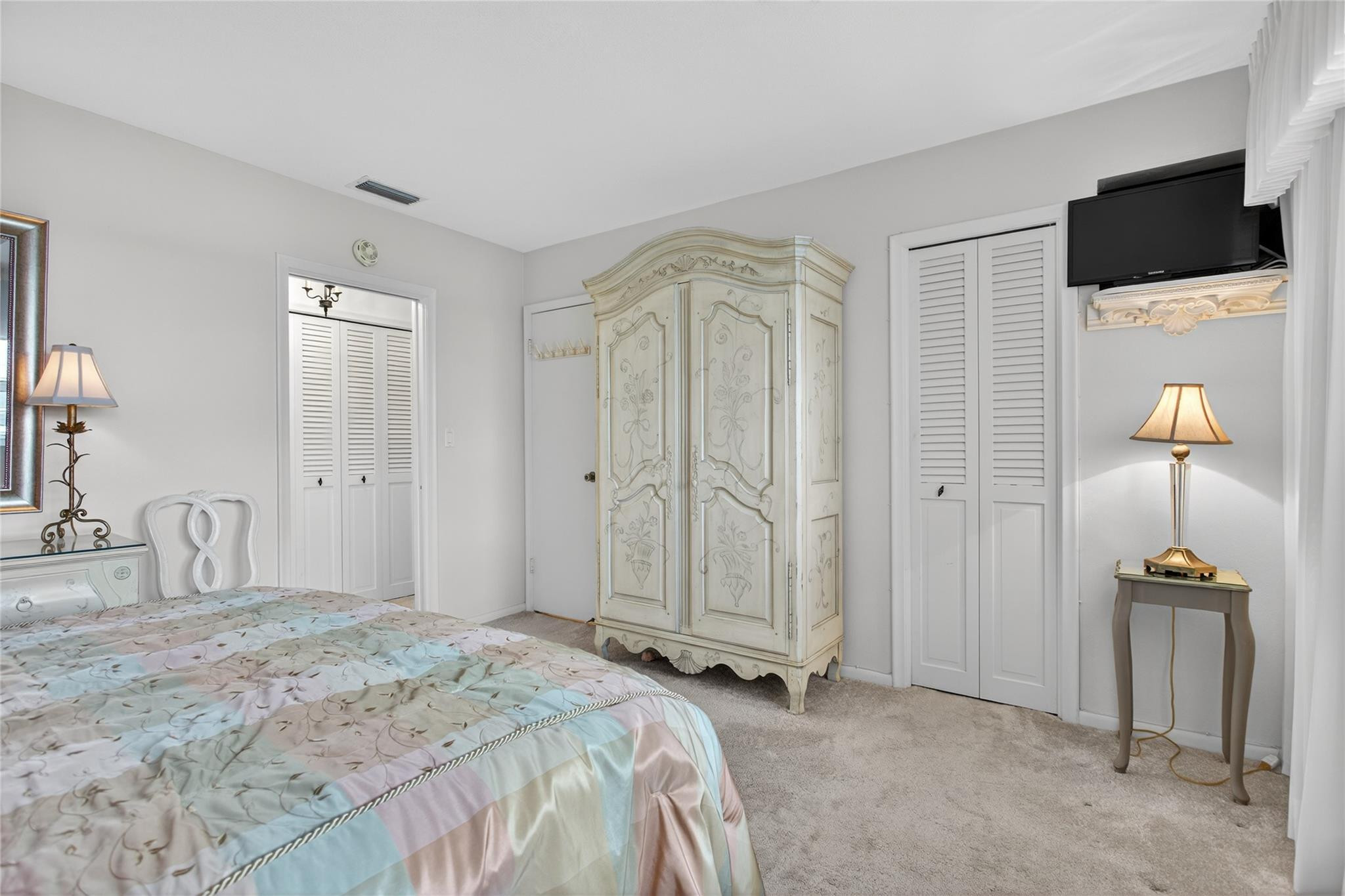 1001 North Riverside Drive, Unit 305 Pompano Beach, FL 33062 - Photo 25 of 44 a bedroom with a bed and a flat tv screen on wall