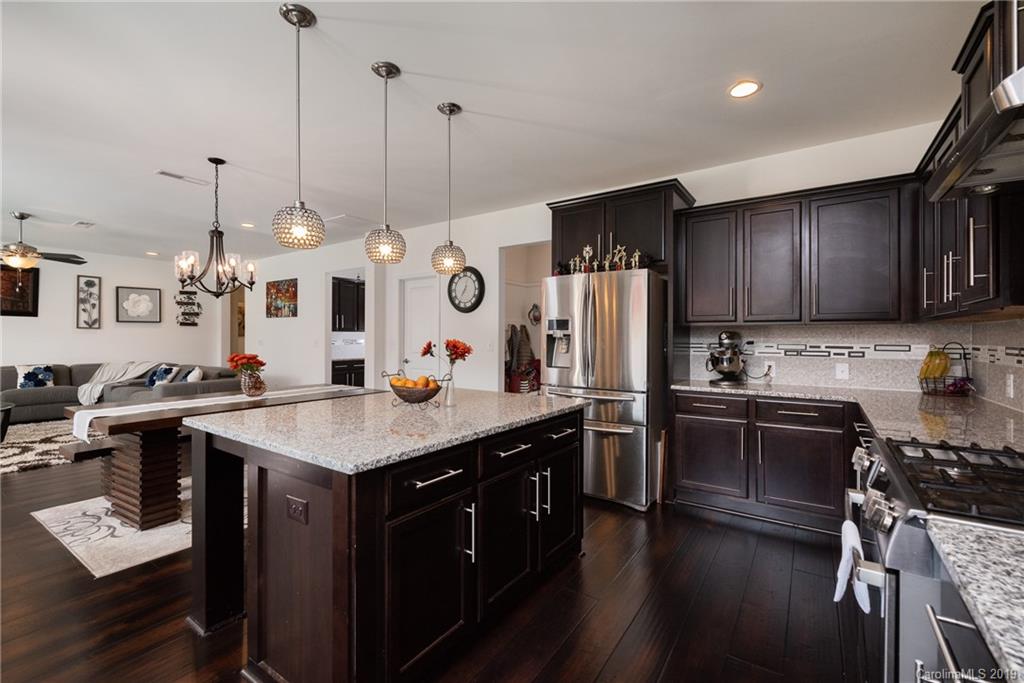 290 Fischer Road Fort Mill, SC 29715 - Photo 15 of 35 a kitchen with stainless steel appliances kitchen island granite countertop a sink a stove a refrigerator and island with wooden floor