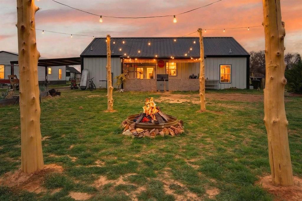 Backyard fire pit and gathering area with string lighting