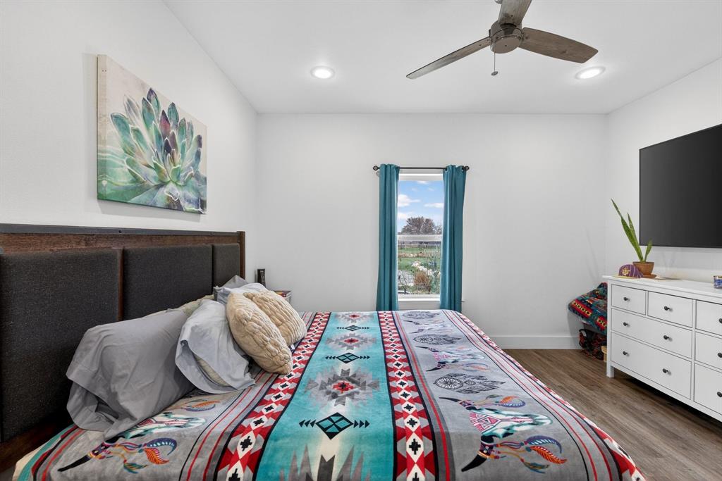 2225 West J E Woody Road Springtown, TX 76082 - Photo 15 of 29 a bedroom with a bed and a flat screen tv
