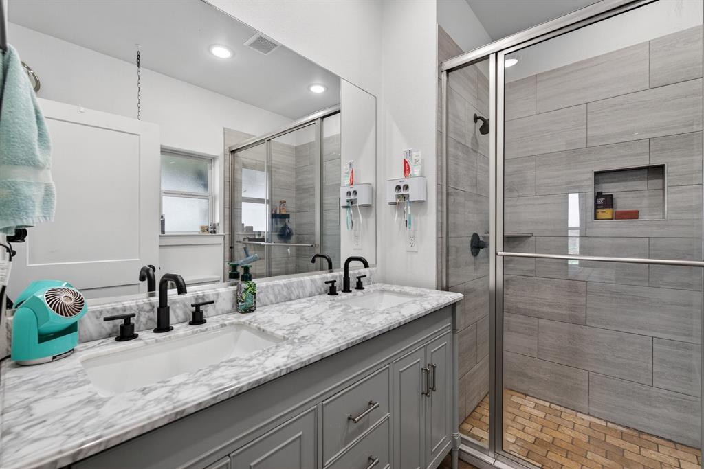 2225 West J E Woody Road Springtown, TX 76082 - Photo 16 of 29 a bathroom with a granite countertop sink a mirror and shower