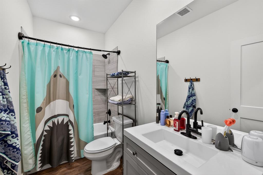2225 West J E Woody Road Springtown, TX 76082 - Photo 19 of 29 a bathroom with a sink a toilet and a mirror