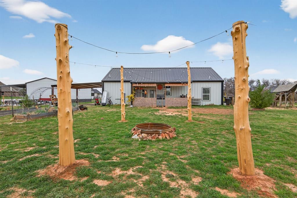 2225 West J E Woody Road Springtown, TX 76082 - Photo 22 of 29 a backyard of a house with table and chairs