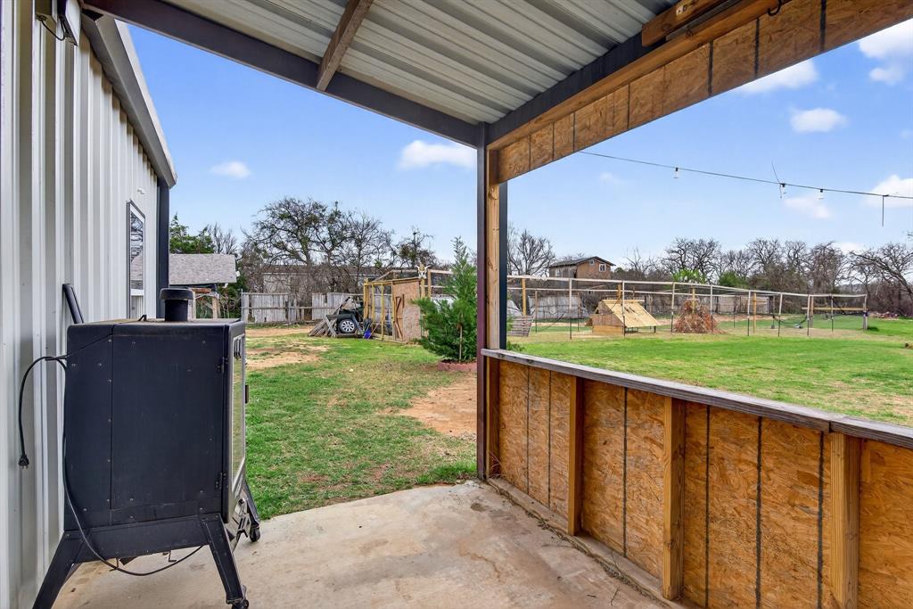 2225 West J E Woody Road Springtown, TX 76082 - Photo 3 of 29 a view of a patio with a table chairs and a backyard