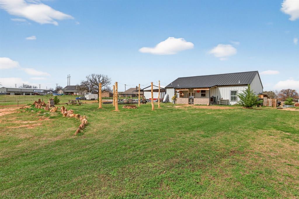 2225 West J E Woody Road Springtown, TX 76082 - Photo 7 of 29 a view of a house with a yard and sitting area