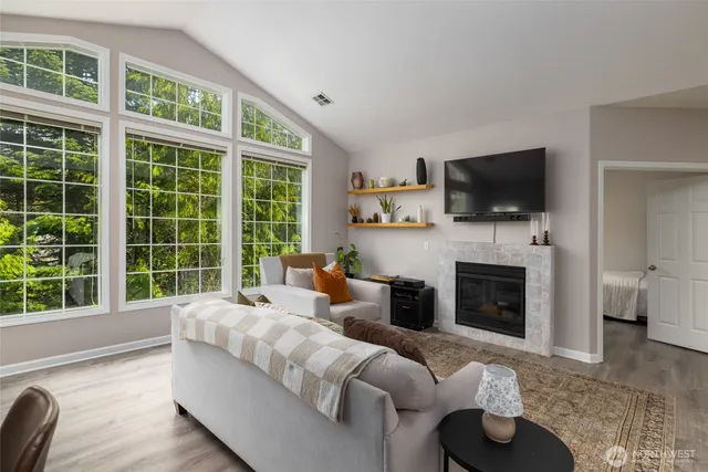 a living room with furniture a fireplace and a flat screen tv