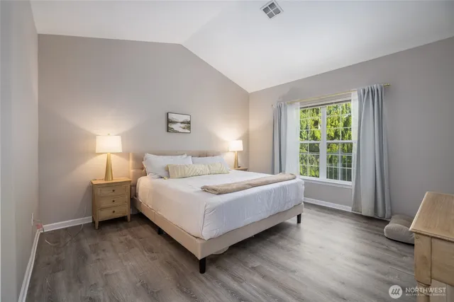 a bedroom with a bed and wooden floor