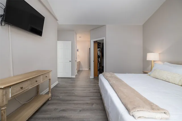 a spacious bedroom with a bed and a flat screen tv