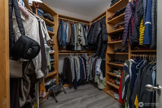 a view of walk in closet with clothes and shoes