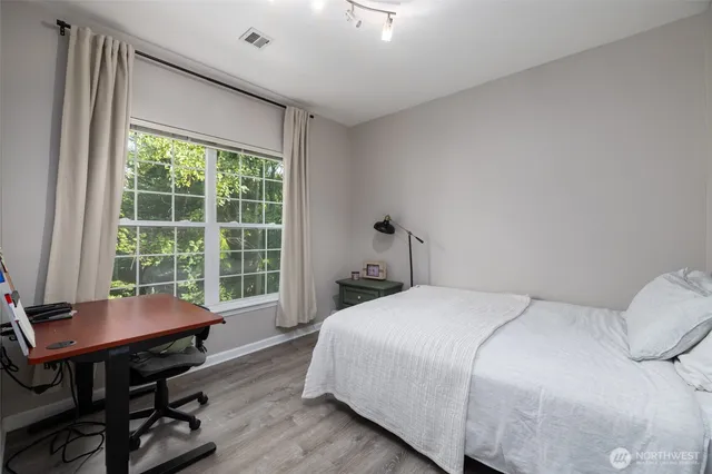 a bedroom with a bed chair and a large window