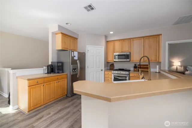 a kitchen with stainless steel appliances a refrigerator and a stove top oven