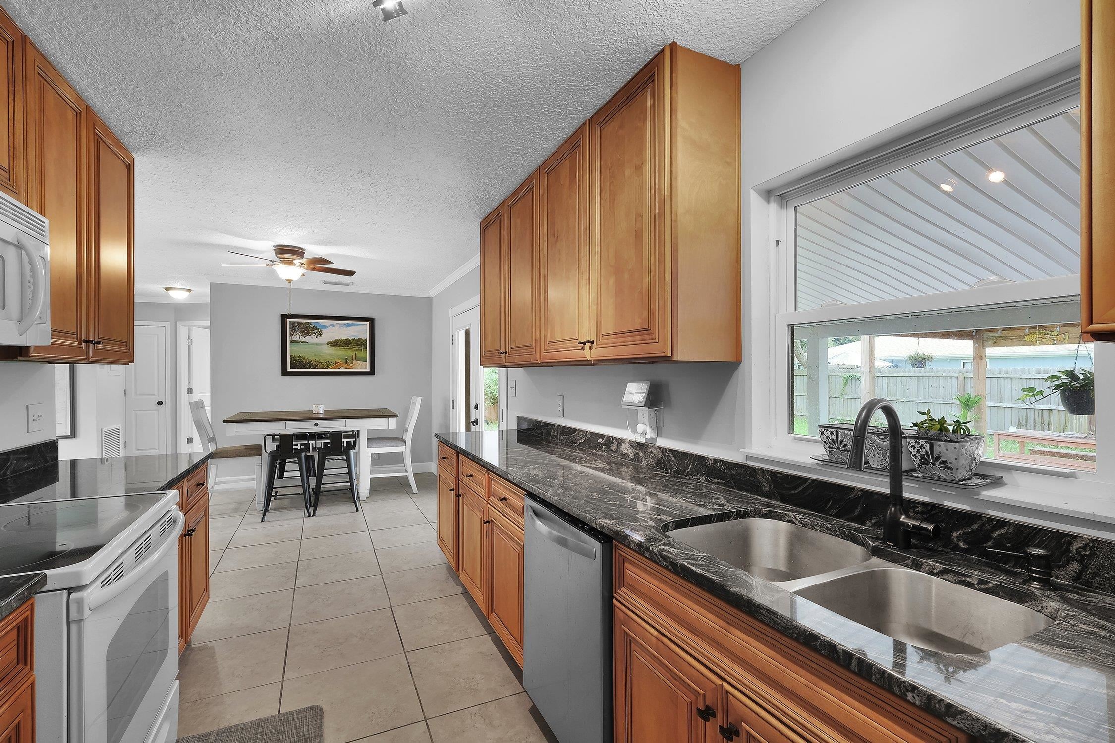 141 Argonaut Road St. Augustine, FL 32086 - Photo 13 of 27 a kitchen with granite countertop a sink and cabinets