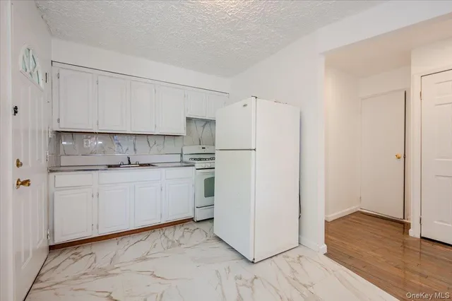 a kitchen with stainless steel appliances white cabinets and wooden floors