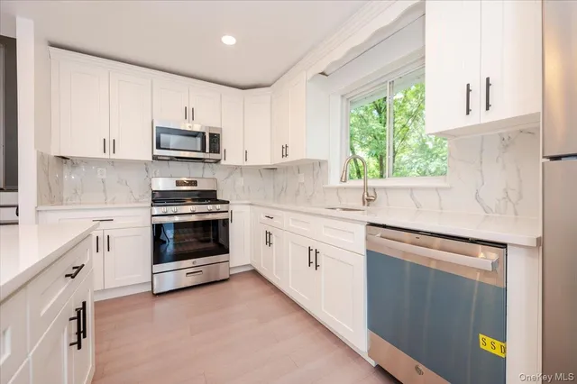 a kitchen with granite countertop white cabinets and white appliances