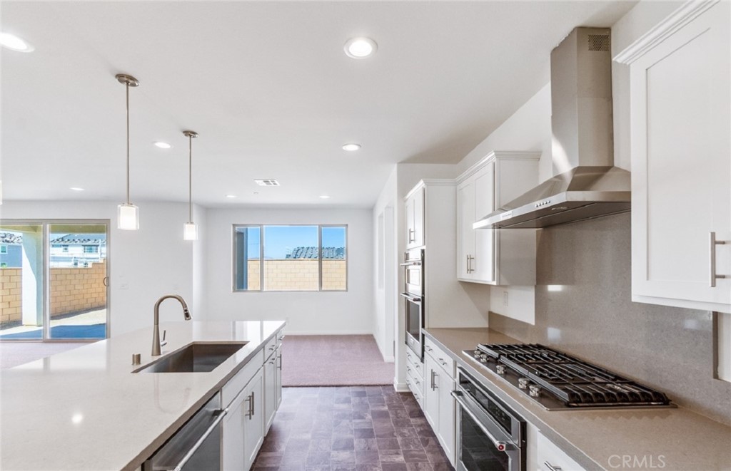 784 Sawgrass Street Perris, CA 92571 - Photo 14 of 46 a kitchen with granite countertop a sink stove and cabinets