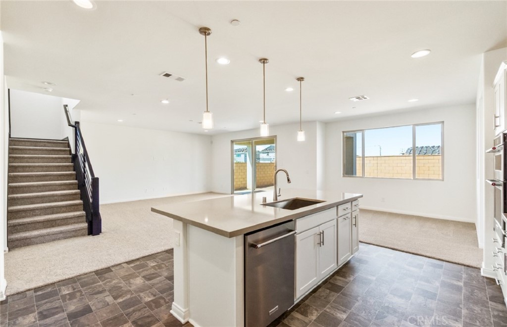 784 Sawgrass Street Perris, CA 92571 - Photo 15 of 46 a kitchen that has a sink a stove and a wooden floor