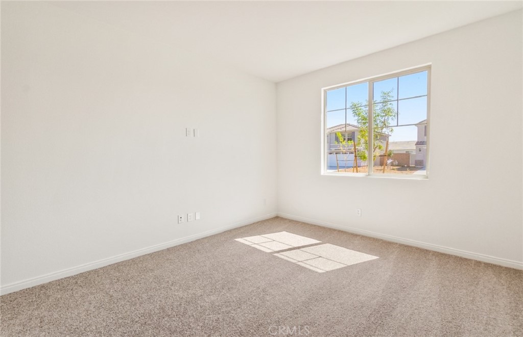 784 Sawgrass Street Perris, CA 92571 - Photo 24 of 46 an empty room with windows and wooden floor