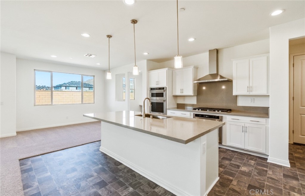 784 Sawgrass Street Perris, CA 92571 - Photo 7 of 46 a kitchen with stainless steel appliances granite countertop a sink a stove and a wooden floor