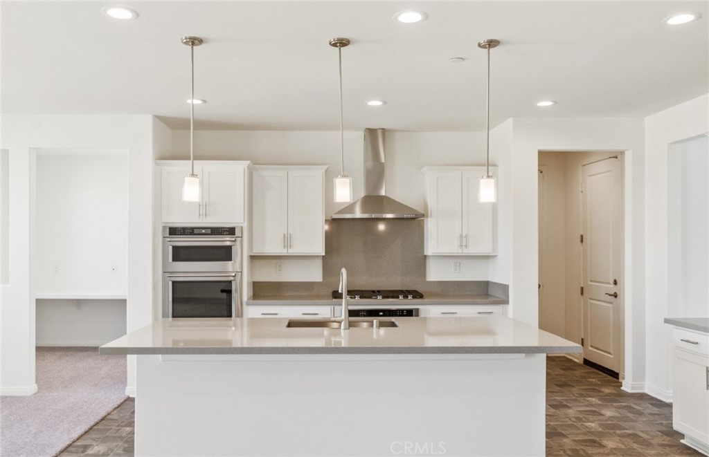784 Sawgrass Street Perris, CA 92571 - Photo 8 of 46 a kitchen with kitchen island a counter top space a sink stainless steel appliances and cabinets