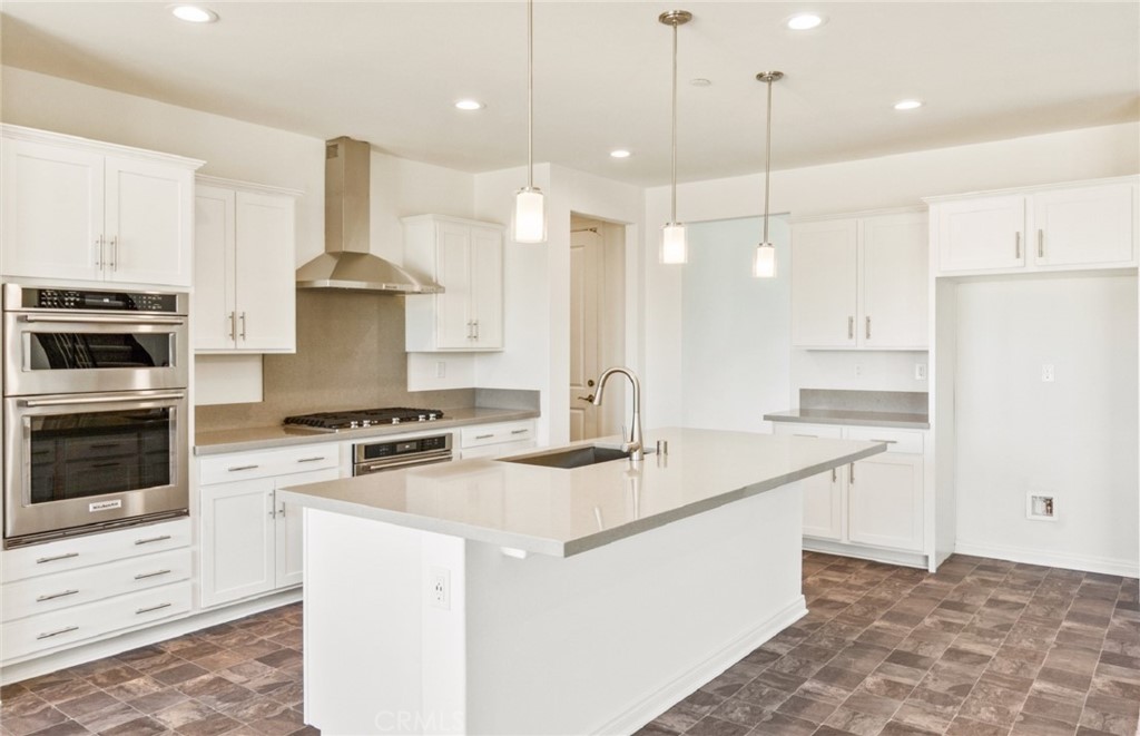 784 Sawgrass Street Perris, CA 92571 - Photo 9 of 46 a kitchen with stainless steel appliances granite countertop a sink a stove a refrigerator and island with wooden floor