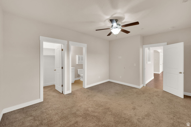 1823 North Crest Road Saratoga Springs, UT 84045 - Photo 12 of 18 Unfurnished bedroom with a spacious closet, light colored carpet, a ceiling fan, and ensuite bath