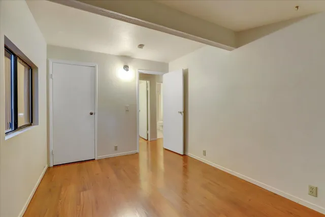 a backyard of a house with large trees and wooden fence