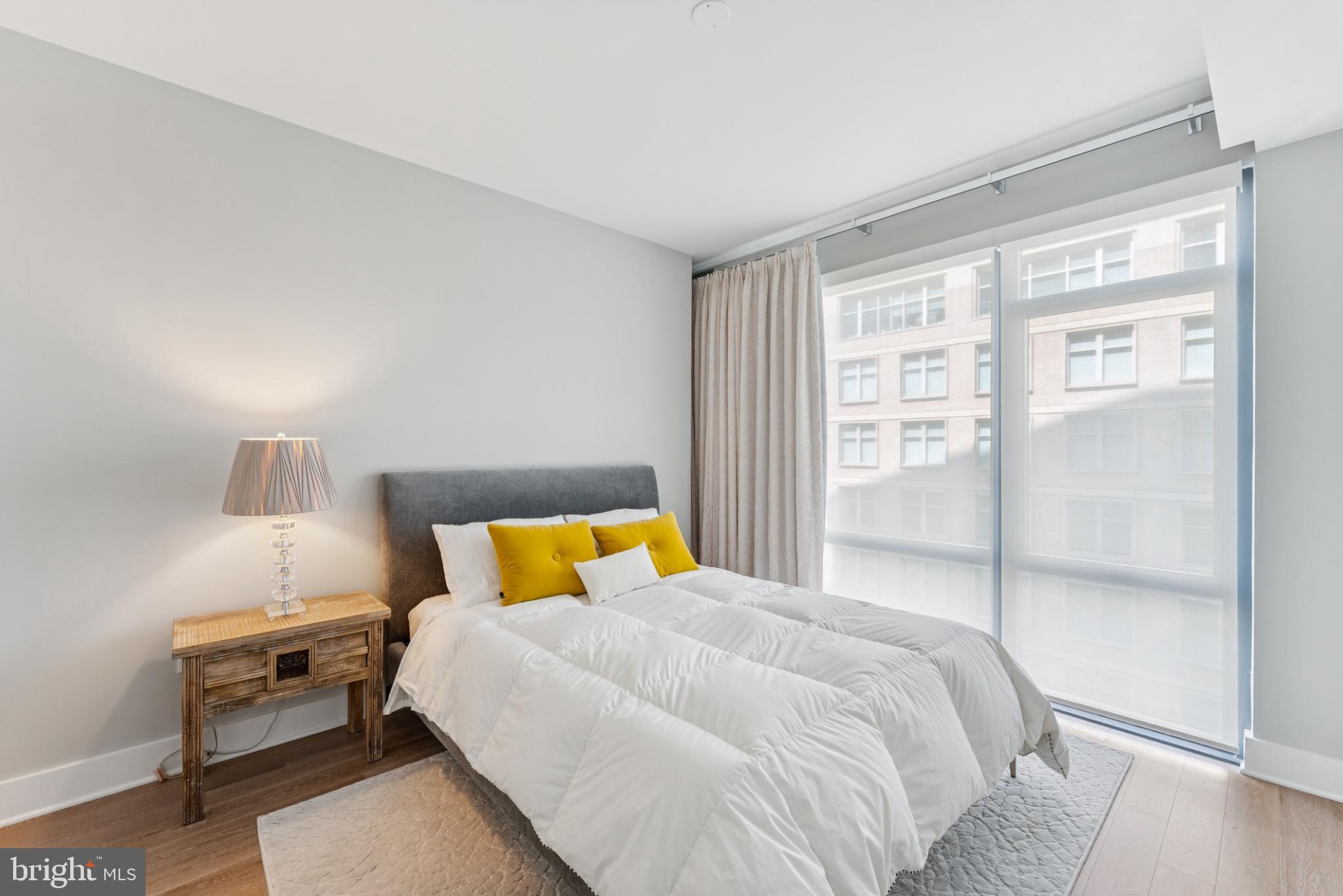 4960 Fairmont Avenue, Unit 904 Bethesda, MD 20814 - Photo 10 of 20 a bedroom with a bed and wooden floor