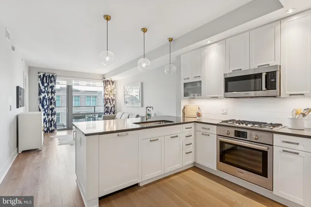 a kitchen with granite countertop a stove a sink and wooden floor