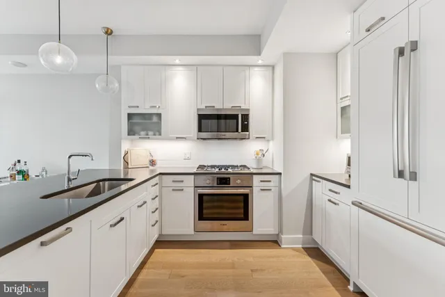a kitchen with stainless steel appliances a stove a sink and a microwave